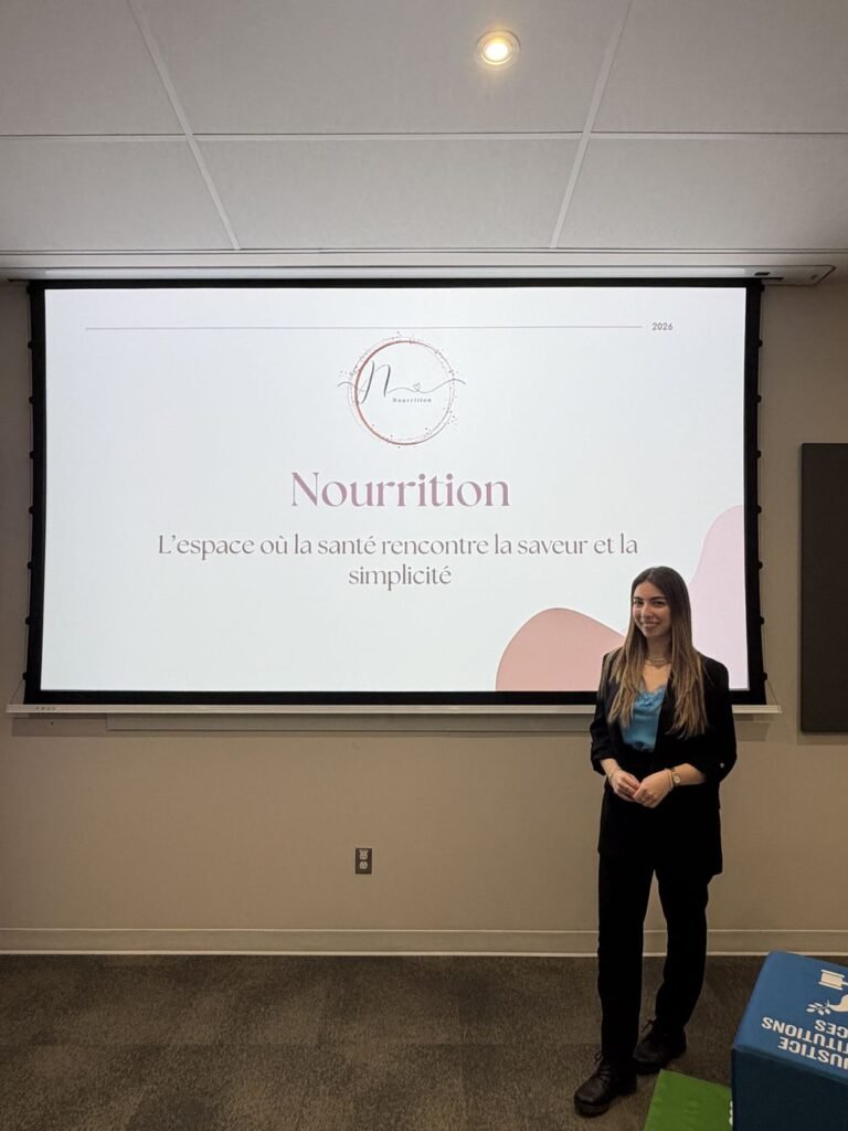 Nour presenting Nourrition in front of a screen showing the Nourrition logo